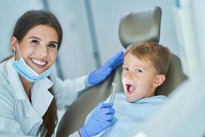 kleiner junge und zahnärztin in der zahnarztpraxis foto