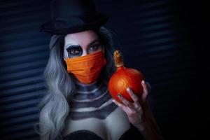 gruseliges porträt einer frau in halloween-gotischem make-up mit schutzmaske foto