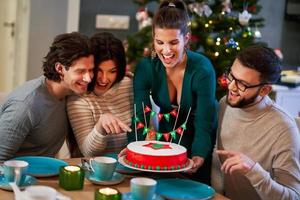 gruppe von freunden, die weihnachten zu hause mit ausgefallenem kuchen feiern foto