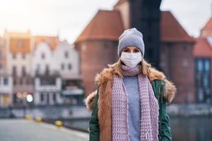Frau mit Gesichtsmaske wegen Luftverschmutzung oder Virusepidemie in der Stadt foto
