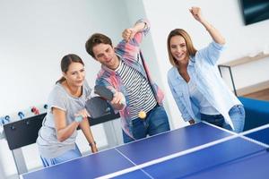 Gruppe von Studenten, die auf dem Campus Tischtennis spielen foto