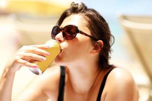 glückliche Frau, die sich im Sommer am Strand entspannt foto