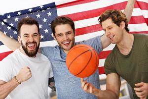 Fröhliche amerikanische Basketballfans jubeln über die Flagge foto