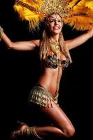 Brasilianerin posiert im Samba-Kostüm auf schwarzem Hintergrund foto
