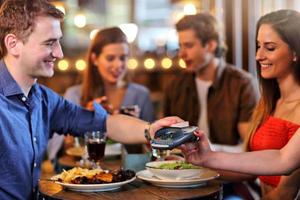 gruppe von freunden, die für das essen im restaurant bezahlen foto