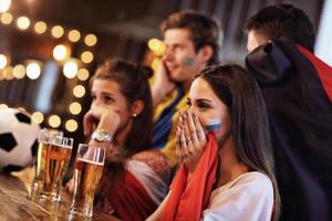 Gruppe von Freunden, die in der Kneipe Fußball schauen foto