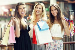 glückliche freundinnen, die im einkaufszentrum einkaufen foto