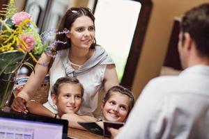 glückliche familie checkt im hotel an der rezeption ein foto