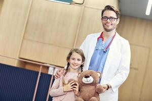 Arzt begrüßt kleines Mädchen in der Klinik foto