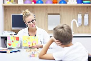 kinderpsychologe, der mit jungen im büro arbeitet foto