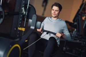 erwachsener mann, der in einem fitnessstudio trainiert foto