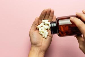 Zinktabletten in der Hand auf rosafarbenem Hintergrund. foto