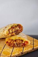 pastor mexikanischer burrito mit fleisch und scharfer sauce foto