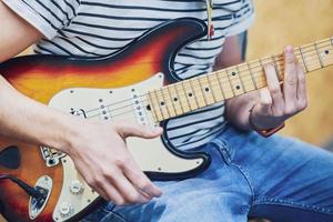 gutaussehender Mann, der im Studio Gitarre spielt foto