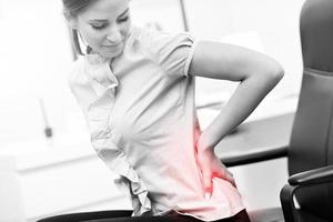 Geschäftsfrau mit Rückenschmerzen foto