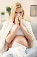 Kranke schwangere Frau, die auf dem Sofa ruht foto