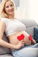 glückliche schwangere Frau, die auf dem Sofa ruht foto