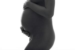 schwangere Frau posiert auf weißem Hintergrund foto