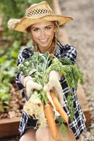 Erwachsene Frau Gemüse aus dem Garten pflücken foto
