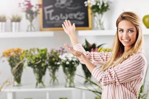 weibliche floristin, die im blumenladen arbeitet foto