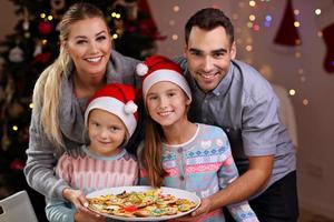 glückliche familie, die weihnachtskekse zubereitet foto