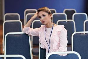 junge Frau sitzt allein im Konferenzraum foto