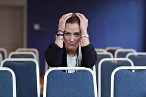 junge Frau sitzt allein im Konferenzraum foto