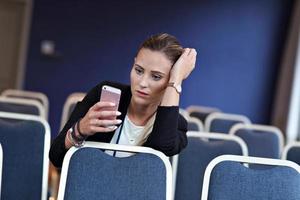 junge Frau sitzt allein im Konferenzraum foto