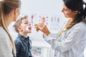 kleiner Junge mit ärztlicher Untersuchung durch Kinderarzt foto