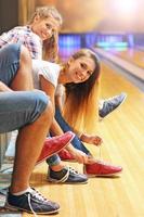 Freunde ziehen Bowlingschuhe an foto