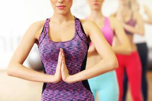 Gruppe von Frauen, die sich im Fitnessstudio dehnen foto