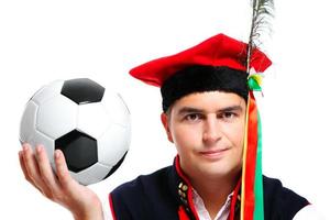 polnischer Mann in traditioneller Kleidung mit Fußball foto