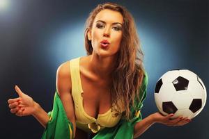 glücklicher brasilianischer fan, der mit flagge und fußball jubelt foto