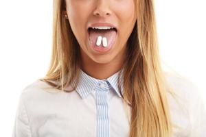 Nahaufnahme einer Frau mit Pille im Mund foto