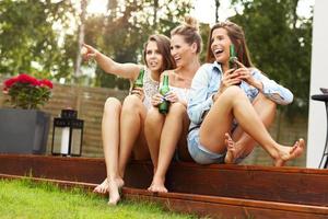 glückliche gruppe von freunden, die draußen bier trinken foto