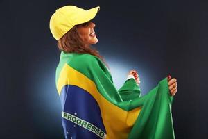 glücklicher brasilianischer fan, der mit flagge jubelt foto