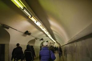 Menschen gehen im U-Bahn-Tunnel. leute gehen auf fußgängerüberweg. foto