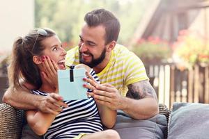 glückliches Paar mit Geschenk draußen sitzen foto