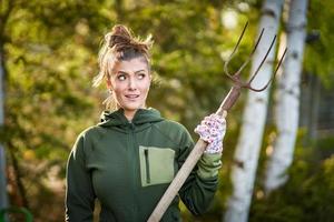 Bild einer Frau, die mit Werkzeugen im Garten arbeitet foto