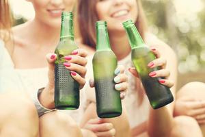 glückliche gruppe von freunden, die draußen bier trinken foto