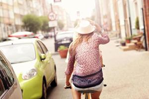 zwei glückliche freundinnen, die tandemfahrrad fahren foto