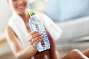 Fit Mädchen mit Flasche Wasser zu Hause im Wohnzimmer foto