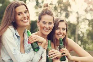 glückliche gruppe von freunden, die draußen bier trinken foto