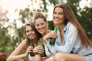 glückliche gruppe von freunden, die draußen bier trinken foto