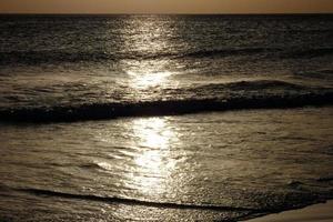 einsamer, nicht überfüllter Strand mit ruhigem Meer und kleinen Wellen foto