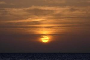 sonnenuntergang über dem meer, sonnenuntergang im herbst am strand von zahara de los atunes, cadiz, andalusien, spanien foto