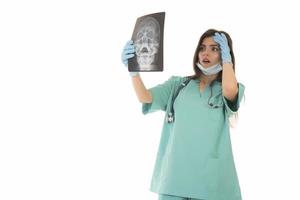 junge ärztin, die sich das röntgenbild ansieht. isoliert auf weiß foto