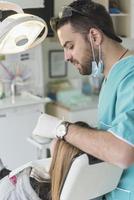 Zahnarzt heilt die Zähne des Patienten und füllt den Hohlraum. zahnarzt, der mit professioneller ausrüstung in der klinik arbeitet. foto