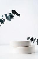 Eine minimalistische Szene eines Gipspodiums mit Steinen auf weißem Hintergrund, für Naturkosmetik foto