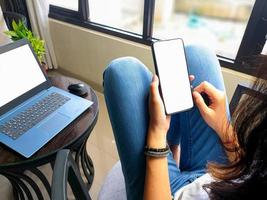 computer, leerer bildschirm telefonmodellbild mit weißem hintergrund für werbung, frauenhand mit laptop und handy auf dem tisch im cafe.mockup foto